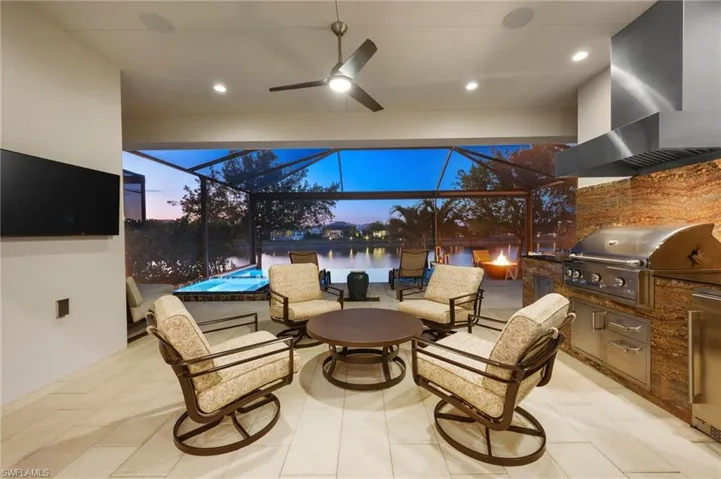 View of patio featuring a grill, a water view, area for grilling, and a lanai