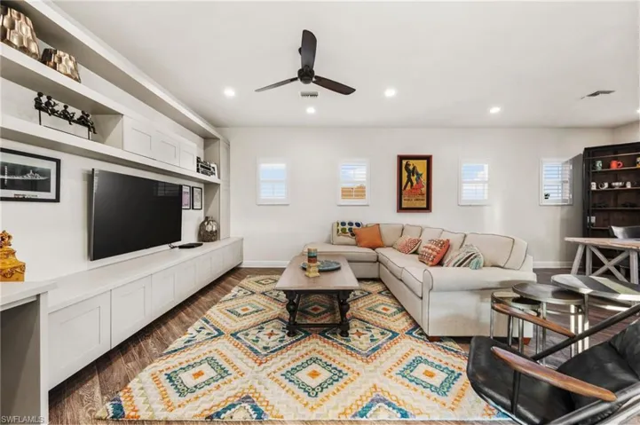 Living room featuring ceiling fan and dark hardwood / wood-style floors