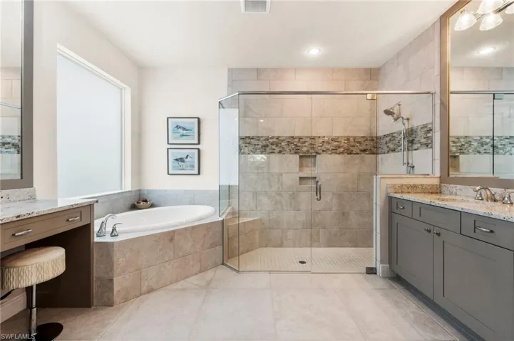Bathroom featuring independent shower and bath, vanity, and tile patterned flooring
