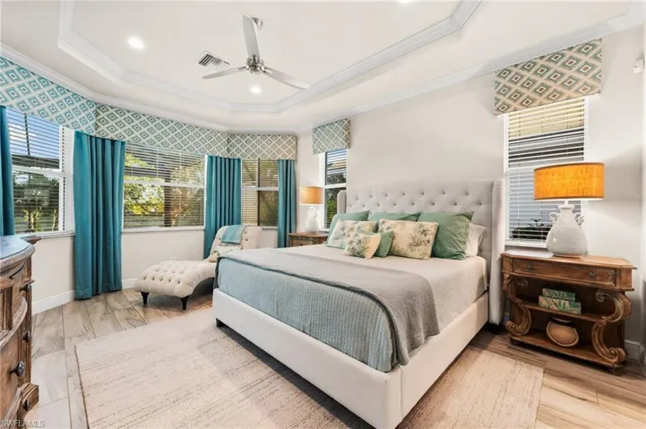 Bedroom with crown molding, a raised ceiling, ceiling fan, and hardwood / wood-style flooring