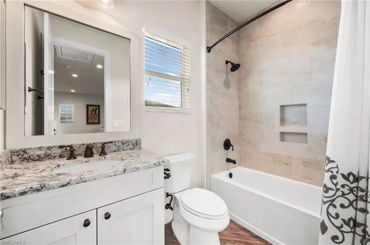 Full bathroom featuring vanity, toilet, hardwood / wood-style floors, and shower / bath combo