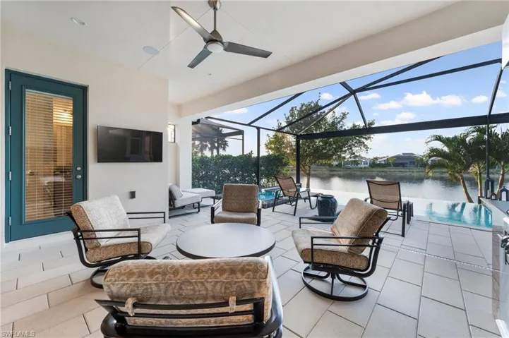 View of patio with ceiling fan, outdoor lounge area, and glass enclosure