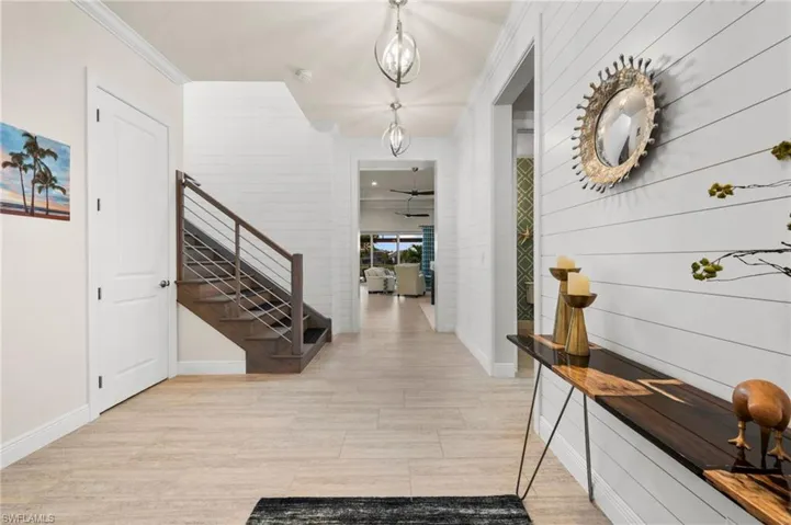Foyer with crown molding and light hardwood / wood-style flooring