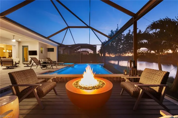 View of swimming pool with an outdoor fire pit, a lanai, and a patio area