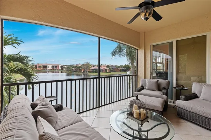 Sunroom with ceiling fan and a water view