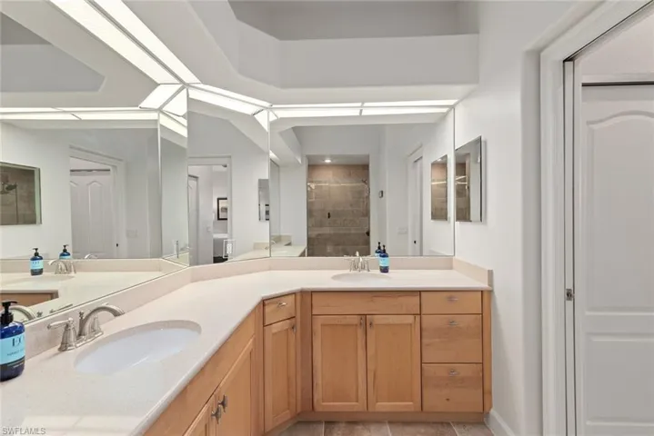 Bathroom featuring vanity, tiled shower, and tile patterned floors