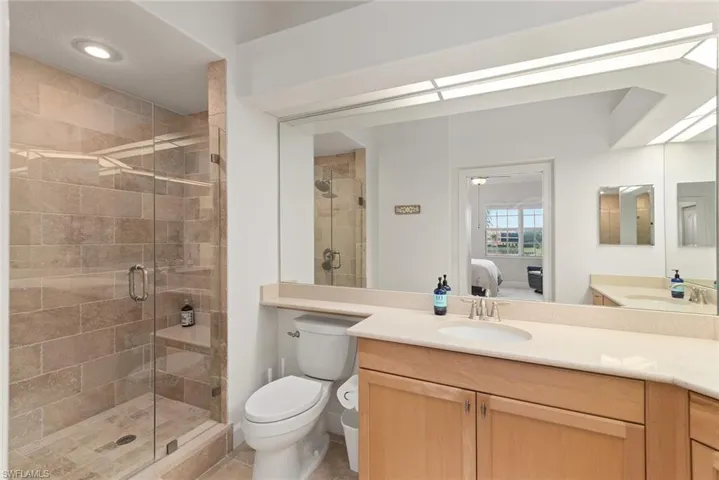 Bathroom featuring toilet, tile patterned floors, walk in shower, and vanity