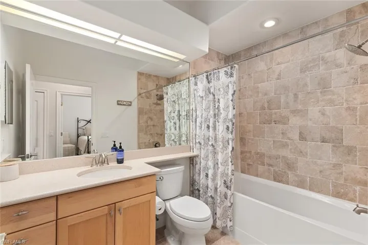Full bathroom with toilet, vanity, and shower / bath combo