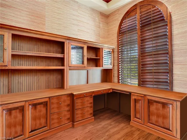 Unfurnished office with built in study area and light wood-style floors