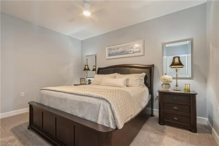 Bedroom with ceiling fan and light carpet