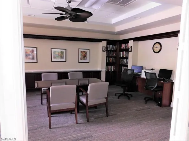 Office with carpet, a raised ceiling, and ceiling fan