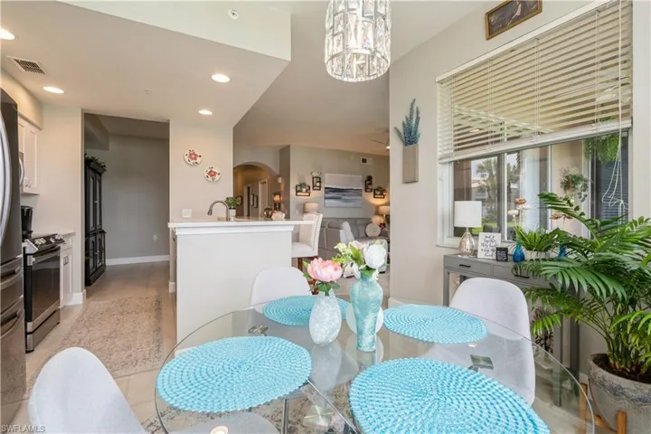 Tiled dining space featuring sink and a chandelier