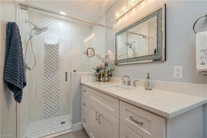 Bathroom featuring a shower with door and vanity