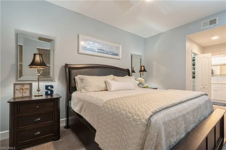 Bedroom with carpet, ensuite bathroom, and ceiling fan