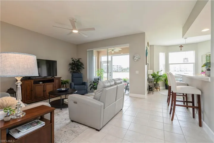 Living room with ceiling fan and light tile patterned floors