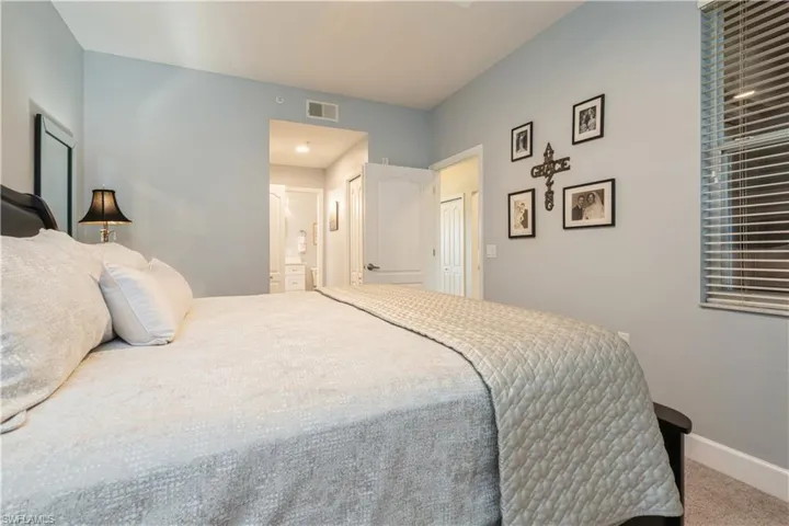 Bedroom featuring carpet floors, a closet, and ensuite bath