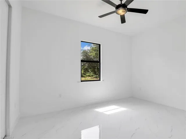 Unfurnished room featuring marble finish flooring and ceiling fan