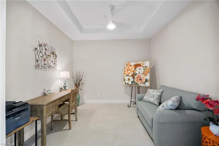 Tiled office space with a raised ceiling and ceiling fan
