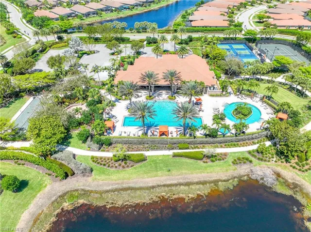 Aerial perspective of suburban area with a large body of water and a pool