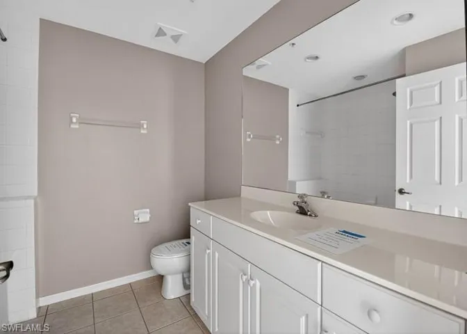 Full bathroom featuring vanity, light tile patterned floors, and a shower