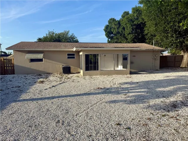 Back of house featuring stucco siding, cooling unit, and fence