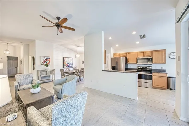 Living area featuring visible vents, baseboards, a ceiling fan, and light tile patterned floors