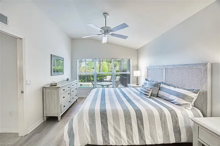 Bedroom with light wood-style flooring, baseboards, a ceiling fan, and vaulted ceiling