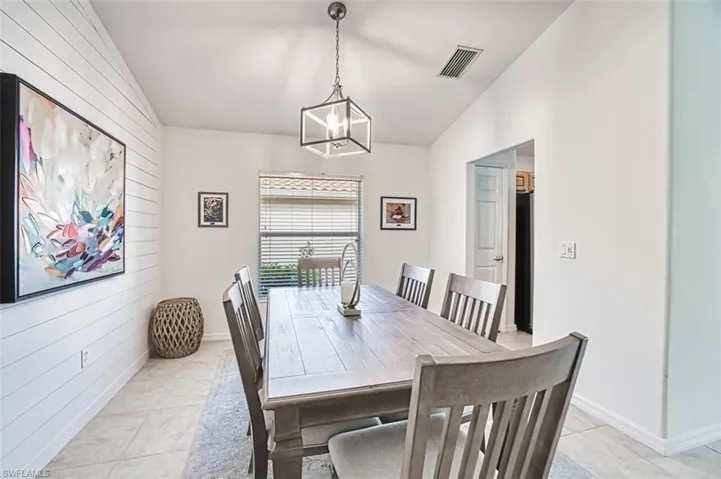 Living room with lofted ceiling, recessed lighting, light tile patterned floors, visible vents, and ceiling fan