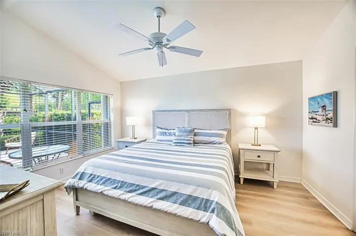 Bedroom featuring light wood finished floors, baseboards, a ceiling fan, and vaulted ceiling
