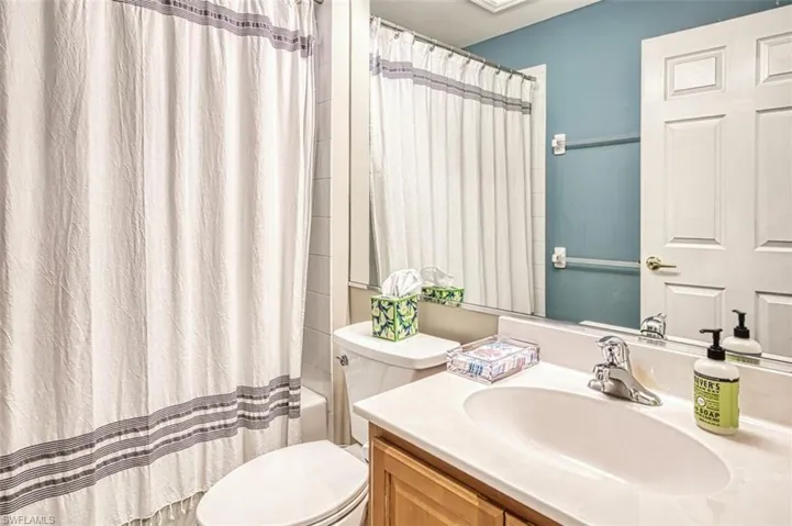 Full bathroom with shower / bath combination with curtain, vanity, and toilet