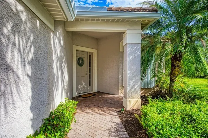 View of front facade featuring a front lawn, driveway, and stucco siding