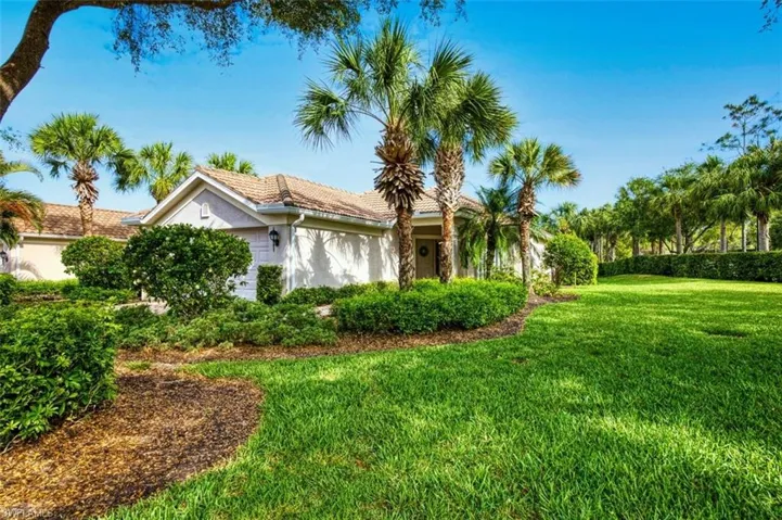 View of side of home with stucco siding, a lawn, and a tile roof