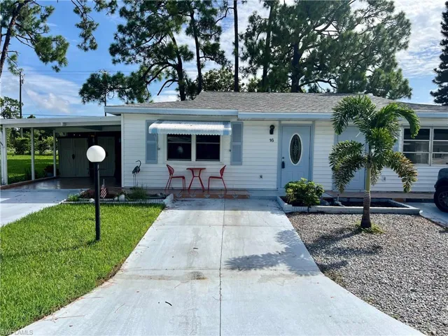 Pinewood Villa featuring a front lawn and a carport