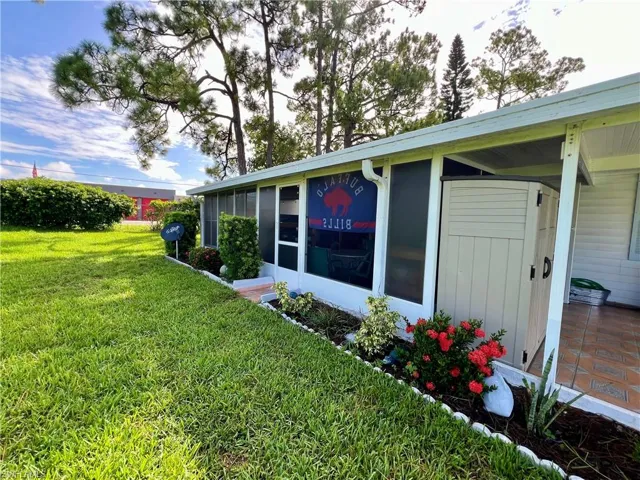View of side of property featuring a lawn