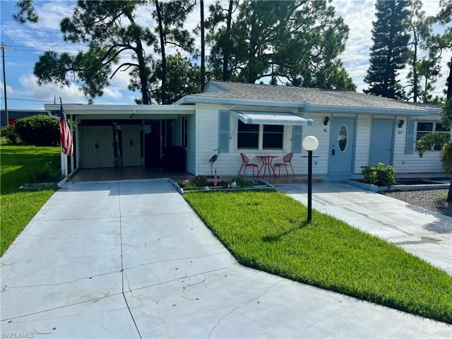 Pinewood Villa featuring a front lawn and a carport