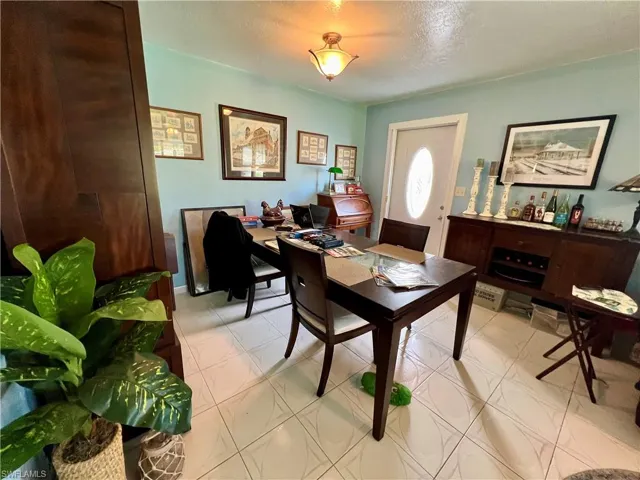 Dining space with light tile patterned flooring and a textured ceiling