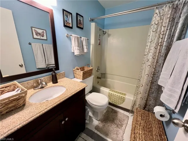 Full bathroom featuring vanity, toilet, tile patterned floors, and shower / tub combo