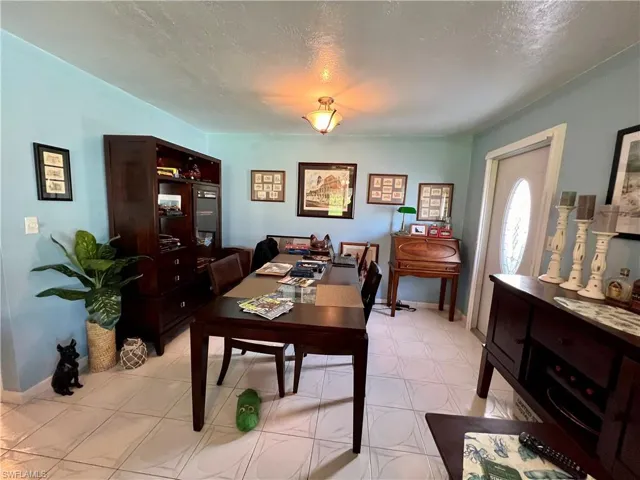Dining room with light tile patterned flooring and a textured ceiling