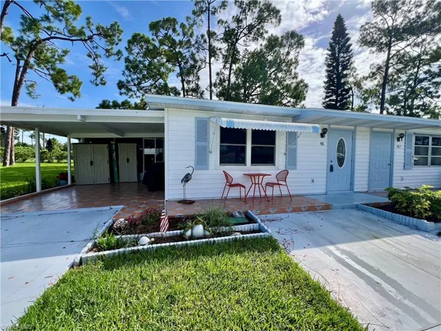View of front facade featuring a front lawn and a carport