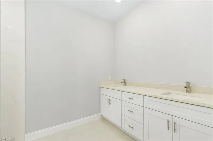 Bathroom featuring double sink vanity and tile patterned floors