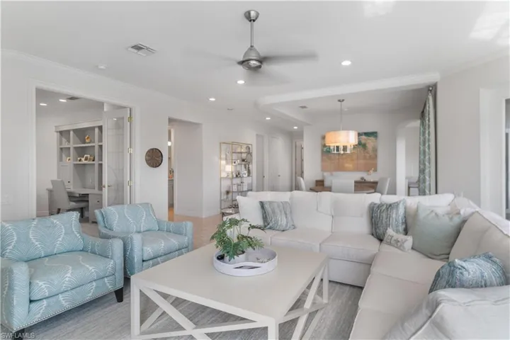 Living area featuring ornamental molding, recessed lighting, visible vents, and a ceiling fan
