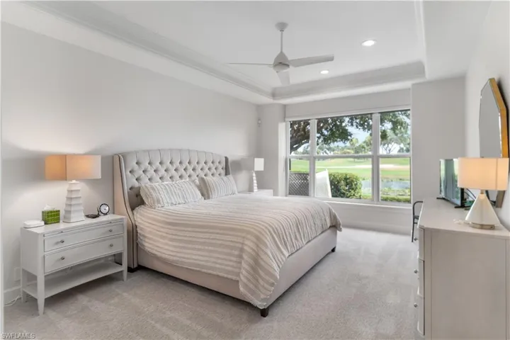 Bedroom with recessed lighting, light carpet, a ceiling fan, ornamental molding, and a raised ceiling