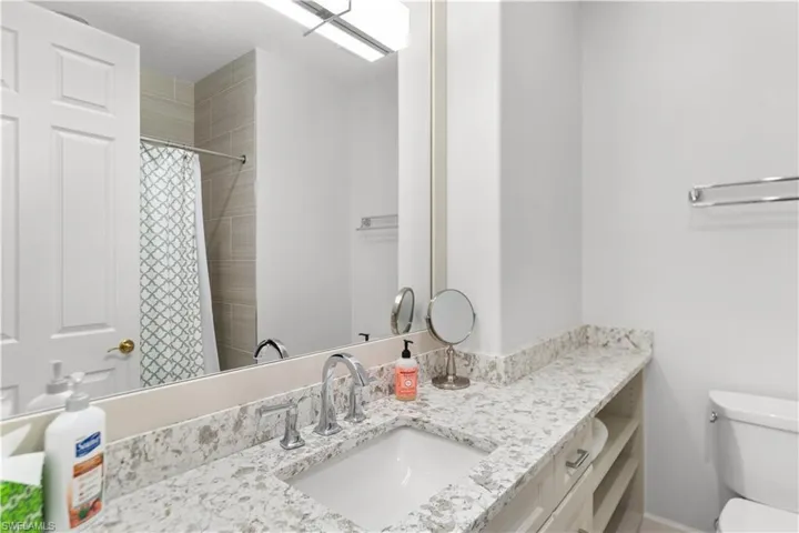 Full bath featuring toilet, curtained shower, and vanity