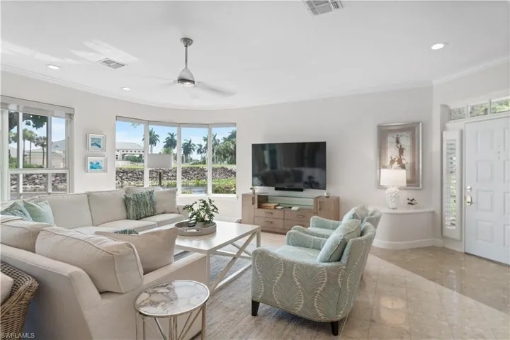Living room with ornamental molding, recessed lighting, visible vents, and a ceiling fan