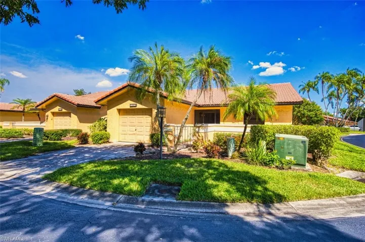 View of front of property with a tile roof, stucco siding, driveway, and a garage