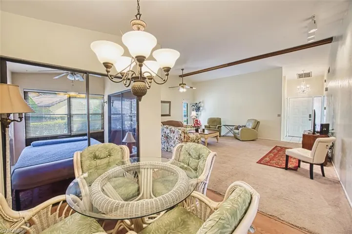 Carpeted dining room featuring a chandelier and ceiling fan