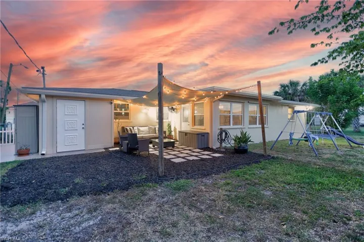 Rear exterior featuring a covered patio, string lighting, and a square paver patio