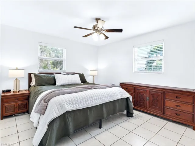 Spacious room featuring neutral white walls and light-toned tile flooring