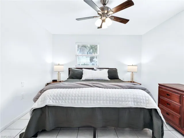 Bright room featuring a window with horizontal blinds, tiled flooring, and a ceiling fan with integrated lighting