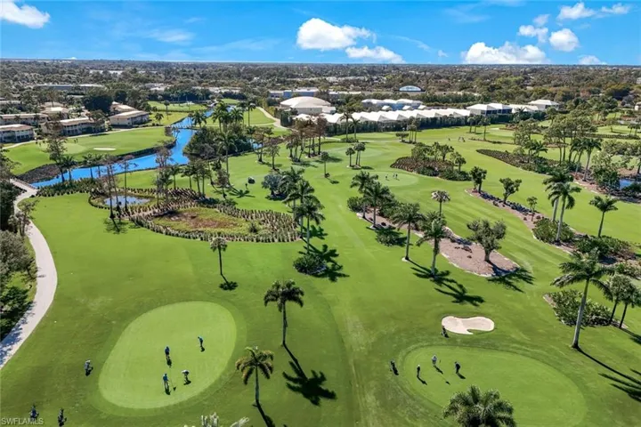 Aerial view of residential area featuring a nearby body of water and a local golf course